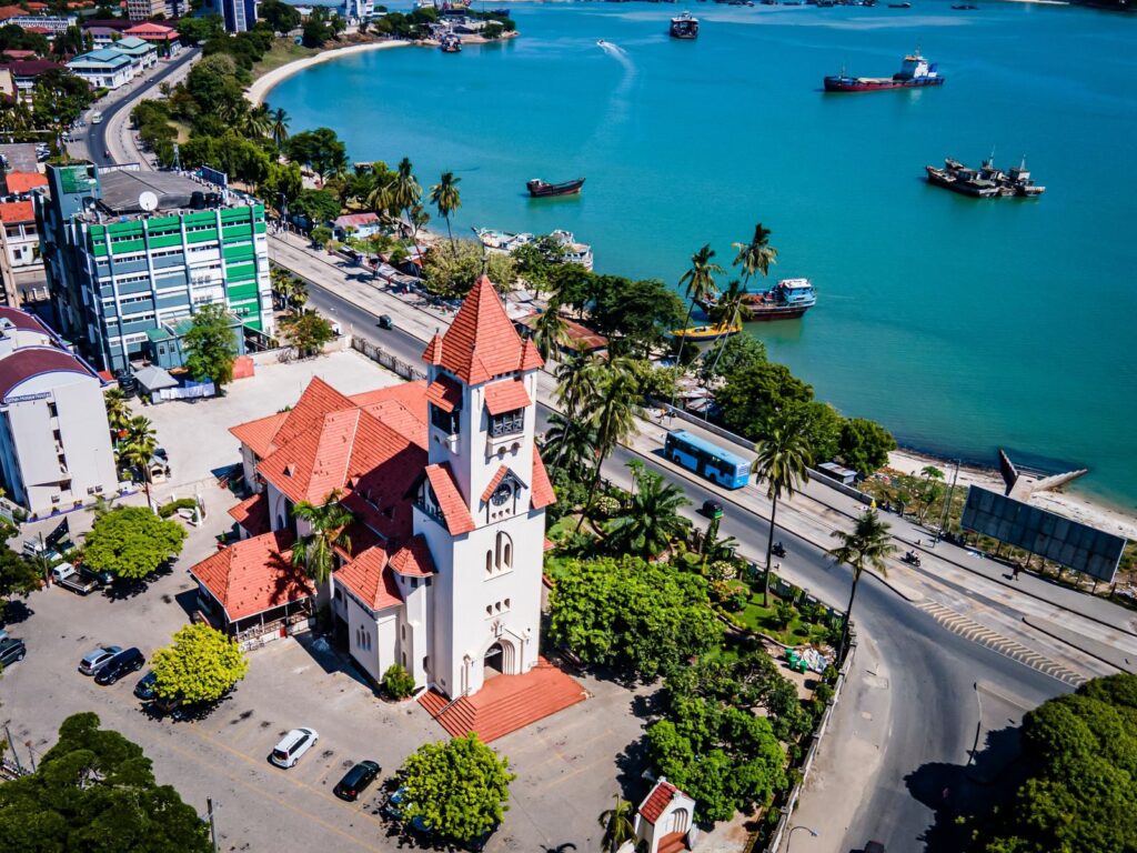 Aerial photograph of Dar es Salaam featuring a church near the coastline under a clear blue sky.